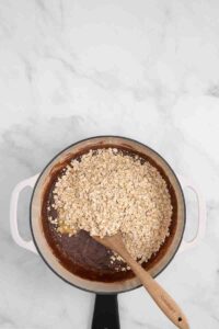stirring in the oats for chocolate peanut butter no bake cookies