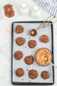 scooped out chocolate no bake cookies with bowl of peanut butter